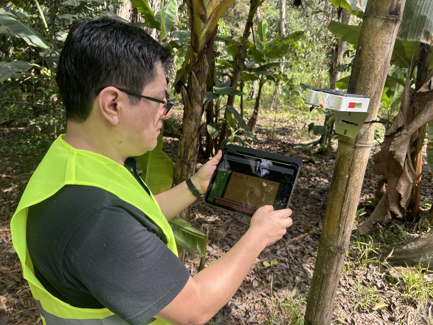 Per-plot readings being checked on a tablet next to the installed gateway during the field test.
